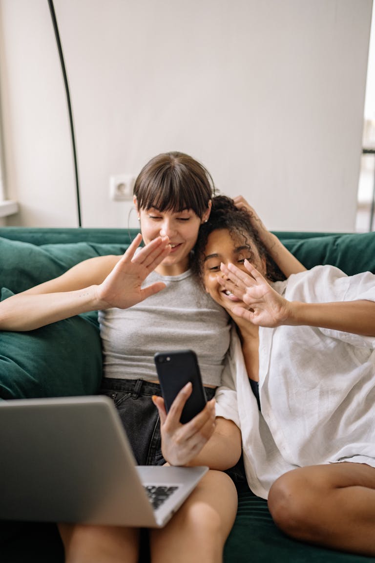 couple smiling while sitting on a couch and using a smartphone and testing meet apps