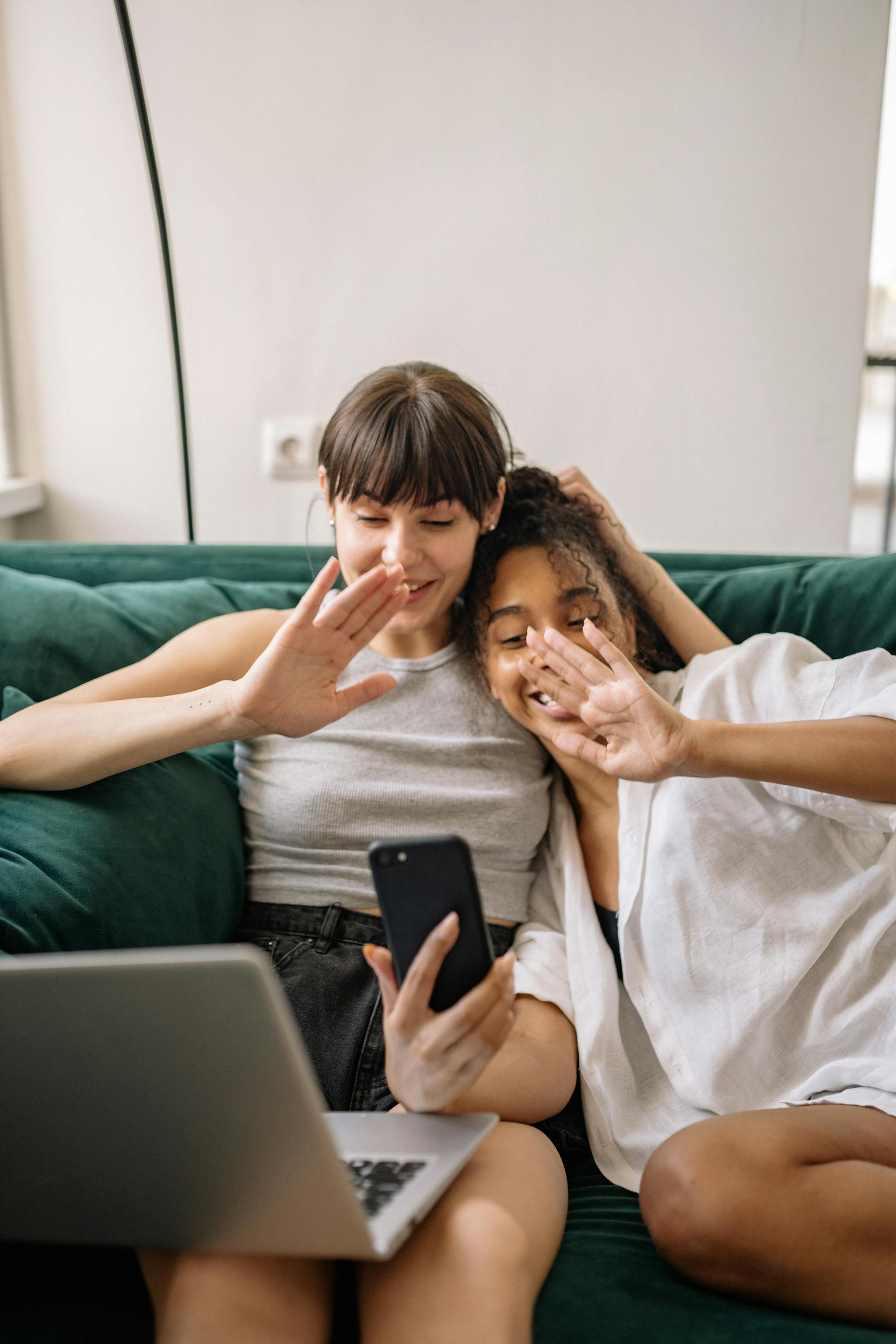 couple smiling while sitting on a couch and using a smartphone and testing meet apps
